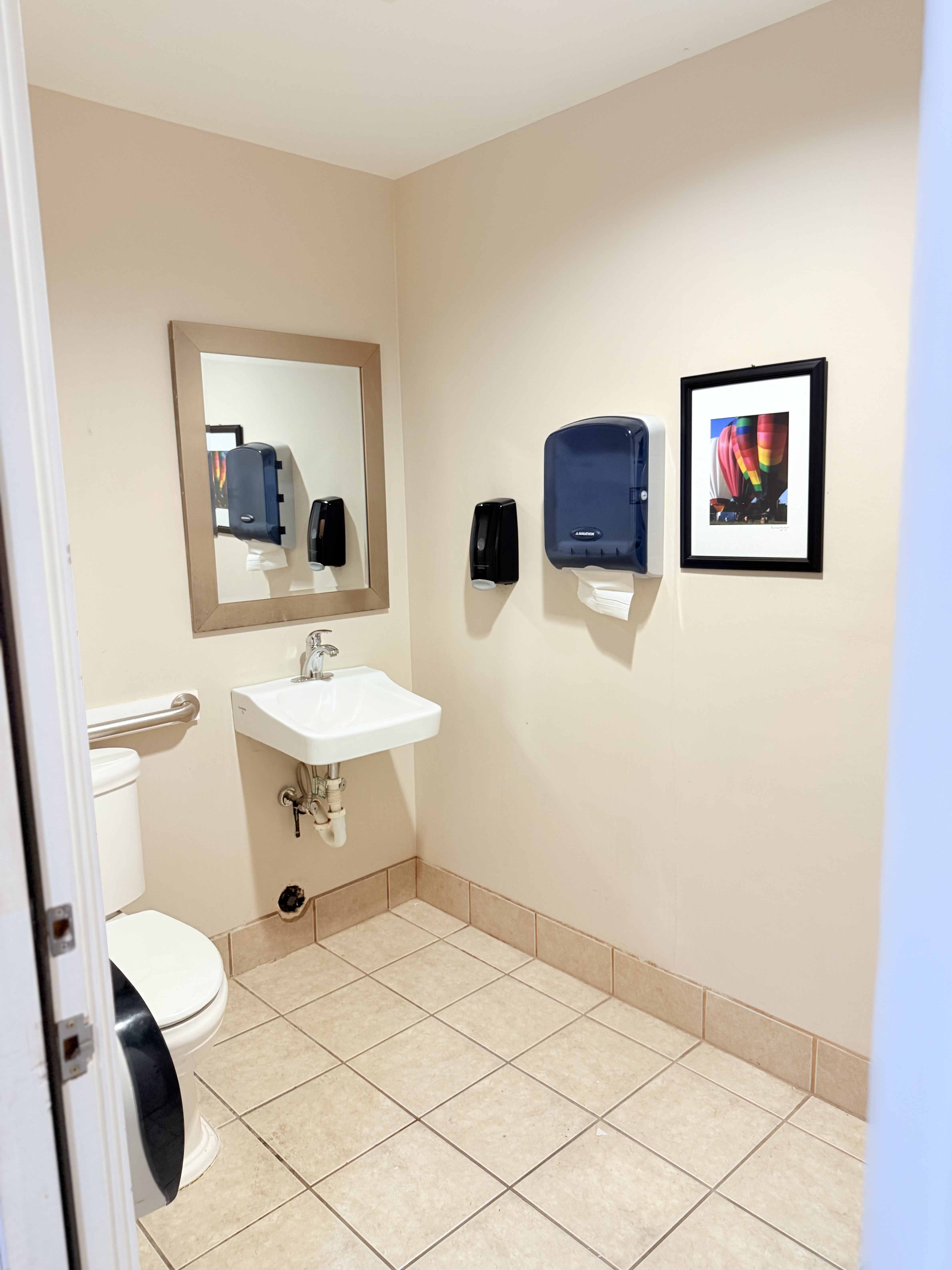 Tenant restroom with sink, mirror, and tile floor